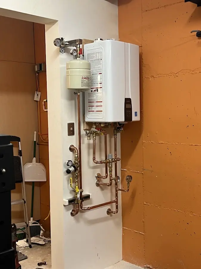 Plumbing technician inspecting water heater connections in Fargo